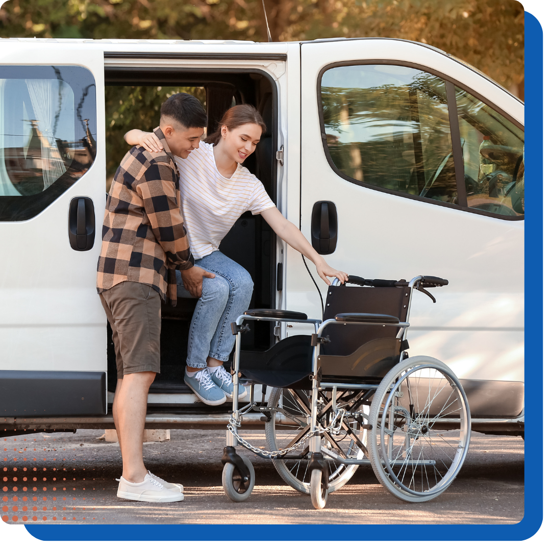 Man helping woman out of a van into a wheelchair